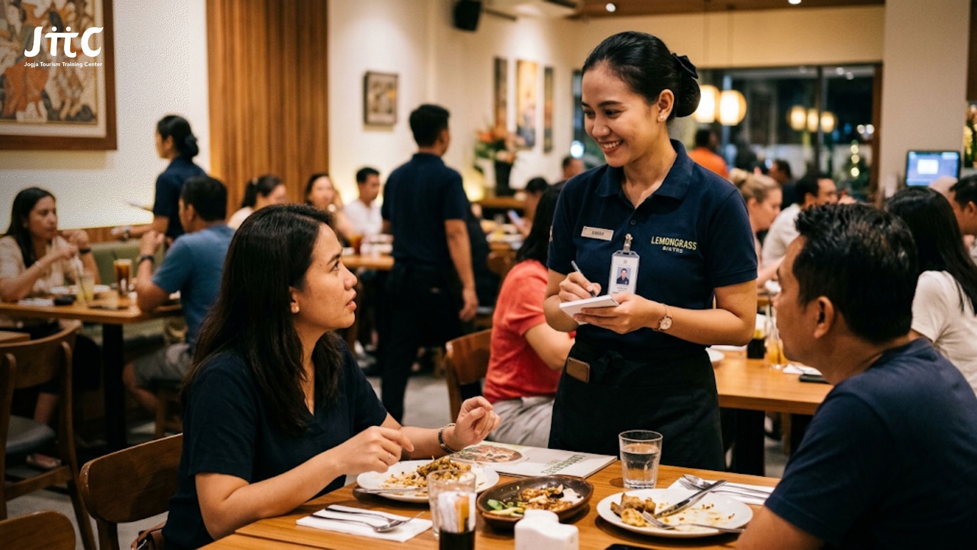 Staf restoran sedang melayani komplain pelanggan dengan senyuman dan sikap profesional