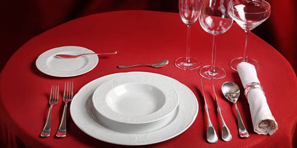 Red table with dinner set. Professional banquet table setting